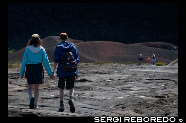 Una pareja haciendo un trekking por encima de la lava del Volcan Pitón de la Fournaise. La isla de Reunión esta forma por dos grandes estrato volcanes de composición principalmente basálticos, yuxtapuestos sobre el fondo oceánico y parcialmente emergidos: el Piton des Neiges al noroeste, más antiguo y extinto desde hace 20.000 años, culmina a 3070 m. El Piton de la Fournaise es un volcán activo que se formó sobre el lado sureste del primero y alcanza los 2631m de altitud. El volumen total emergido de la isla representa 0,8x103 km3, a sea 1/32 del volumen total de la estructura global. Si se tiene en cuenta el volumen oculto en la zona de pliegue monoclinal de la placa, la parte emergida no representa que un centésimo del volumen total. Las primeras manifestaciones eruptivas sobre el fondo del océano a 4000 m profundidad son estimadas ocurrieron hace 4 a 5 mi; el Pitón des Neiges alcanza hoy alrededor de 7000 m de altura desde el fondo del océano.