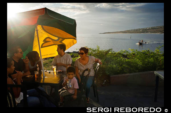 Chiringuitos junto a la playa en Saint Leu. Reunión admite todos los tópicos, todas esas definiciones que con demasiada frecuencia se usan para describir un lugar exótico: crisol de culturas, abanico de contrates, playas de fina arena y aguas transparentes... Todo vale, pero casi todo se queda corto. Un viaje a Reunión (once horas de vuelo desde París) no se justifica solo por eso. A Reunión, ese pedazo de Francia y de Europa en pleno océano Índico, hay que venir con los ojos y la mente bien abiertos. Y dejarse sorprender. Su nombre, sin embargo, no tiene nada de poético. Esta isla que en otras épocas se llamó Al Maghribain, Theemai Theevu, Dina Morgabin, Santa Apolônia, Île Bourbon, por los Borbones franceses, y finalmente Reunión, aunque durante un breve período todavía recibió el nombre de Bonaparte, en honor de quien mandaba en Francia, ha vivido en su nombre los avatares de la metrópoli de la que depende y de los distintos pueblos que la han habitado. El nombre actual fue una concesión política que conmemora la unión de los revolucionarios de Marsella, aquellos que partieron de la ciudad mediterránea cantando lo que luego se convertiría en el himno nacional francés, con la Guardia Nacional de París, que tuvo lugar el 10 de agosto de 1792. 