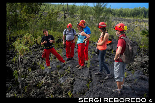 Aymeric. Exploraciones en lava tubes en la zona de Grand Brûlé. Los tubos de lava son un tipo de cueva de lava forman cuando un flujo de lava de baja viscosidad activa desarrolla una corteza continua y dura, que se espesa y forma un techo por encima de la corriente de lava todavía fluye libremente. Los tubos se forman en una de dos maneras: por la formación de costra de canales de lava y flujos de lava pahoehoe donde se mueve bajo la superficie. Lava normalmente sale del punto de erupción en los canales. Estos canales suelen estar muy caliente como su entorno fresco. Esto significa que poco a poco se desarrollan las paredes alrededor de ellos como la lava circundante se enfría y / o como el canal funde su forma más profunda. Estos canales pueden tener suficiente profundidad para formar una costra, formando un tubo aislante que mantiene la lava fundida y sirve como un conducto para el flujo de lava. Estos tipos de tubos de lava tienden a estar más cerca del punto de erupción de lava. Más allá del punto de erupción, la lava puede fluir en un unchanneled, forma de abanico al salir de su origen, que suele ser otro tubo de lava que lleva de nuevo al punto de erupción. Llamado flujos pahoehoe, estas áreas de la superficie de movimiento de lava fría, formando ya sea una superficie lisa o rugosa, viscosa. La lava sigue fluyendo de esta manera hasta que comience a bloquear su fuente. En este punto, la lava bajo la superficie es todavía lo suficientemente caliente para estallar en un punto, y desde este punto de la lava comienza como una nueva "fuente". Lava fluye de la fuente anterior a este punto de ruptura como la lava que rodea el flujo pahoehoe enfría. Esto forma un canal subterráneo que se convierte en un tubo de lava.