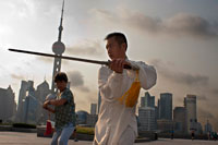 China, Shanghai, por la mañana el ejercicio de tai chi en el Bund. Shanghi Bund: Temprano tai chi ejercicios de la mañana con las espadas en el Bund en Shanghai China. Las mejores lecciones taichi que he tenido eran de un tipo viejo que practicaba fuera a las 7 am cada mañana. Aprendí 4 técnicas excelentes que todavía utilizo en mi entrenamiento MMA de modo regular un método de captura de una patada y tirar a tu oponente, la reorientación de un puñetazo recto y contrarrestar en el mismo movimiento, la lucha contra el doble underhooks con un lanzamiento, y escapar de un cerradura hombro mientras la configuración de su cuenta. Es un arte marcial realmente fascinante, porque cada uno de los movimientos de la danza como representa una lucha práctica sencilla