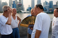 China, Shanghai, morning tai chi exercise on The Bund. Shanghi Bund : Early morning tai chi exercises with swords on the Bund in Shanghai China. The best taichi lessons I've had were from an old guy who practiced outside at 7am every morning. I learned 4 excellent techniques that I still use in my MMA training on a regular basis- a method of catching a kick and throwing your opponent, redirecting a straight punch and countering in the same motion, countering double underhooks with a throw, and escaping a shoulder lock while setting up your own.  It's a really fascinating martial art because every one of those dance like movements represents a simple practical fighting technique or strategy, but it's hard to see how the movements translate into combat applications without a master of the art demonstrating it. But either way even without a kungfu master, the forms themselves are great low impact exercise that you can find everywhere in the city for free every morning. 