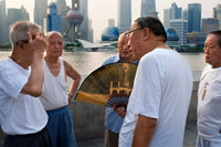 China, Shanghai, morning tai chi exercise on The Bund. Shanghi Bund : Early morning tai chi exercises with swords on the Bund in Shanghai China. The best taichi lessons I've had were from an old guy who practiced outside at 7am every morning. I learned 4 excellent techniques that I still use in my MMA training on a regular basis- a method of catching a kick and throwing your opponent, redirecting a straight punch and countering in the same motion, countering double underhooks with a throw, and escaping a shoulder lock while setting up your own.  It's a really fascinating martial art because every one of those dance like movements represents a simple practical fighting technique or strategy, but it's hard to see how the movements translate into combat applications without a master of the art demonstrating it. But either way even without a kungfu master, the forms themselves are great low impact exercise that you can find everywhere in the city for free every morning. 