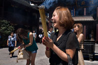 Templo y pagoda Dios, templo budista en Shanghai, la quema de incienso, incienso. A reza la mujer y se ríe de Chenghuang Miao o Dios de la Ciudad del Templo en Jardines de Yu Yuan bazar Shanghai, China. Situado junto al Jardín Yuyuan y también conocido hoy como el Yu Garden Market, el Templo del Dios de la Ciudad (Templo Chenghuang) fue construida en el siglo XV, durante la dinastía Ming. Originalmente un templo construido en honor del estadista Han Huo Guang (68 aC) El Templo del Dios de la Ciudad es un templo taoísta que se compone de muchas salas como el Gran Hall, Medio Hall, Palacio Dormitorio, Star Dioses Hall, Yama Palace, Xuzhen Dios Hall. El templo tenía una superficie de más de 10.000 metros cuadrados, incluyendo dos jardines: West Garden (Jardín Yuyuan) y East Garden.