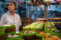 Restaurant al casc antic, Shanghai. Safates de vapor de bambú amb opcions de dim sum en un petit restaurant a l'antiga ciutat de Déu Temple a Xangai Old Street. Costat de la carretera xinès Dumpling o Dim Sum Stall a la Ciutat Vella, Shanghai, Xina. Xiaolongbao és un tipus de pasta al vapor (baozi) de la regió de Jiangnan de la Xina, especialment associat amb Xangai i Wuxi. Es prepara tradicionalment en Xiaolong