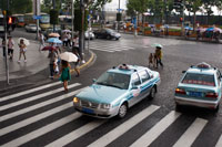 Dos taxis en un día de lluvia en Shanghai, China. Volkswagen Santana taxis de fabrica en una empresa conjunta Shanghai con el coche alemán. Shanghai cuenta con alrededor de 45.000 taxis, operado por más de 150 compañías de taxis. Varias compañías tienen taxis en sus propios colores. Hay siete empresas más populares - Dazhong Taxi Compañía con sus coches en el cielo azul; Qiangsheng con sus coches de color naranja; Blanco Jinjiang; Verde Bashi; Haibo zafiro azul; Fanlanhong rojo; y Lanse Lianmeng en azul marino. De todas las empresas, se recomiendan con más fuerza Dazhong y Qiangsheng. Tomando taxis en Shanghai es más caro que en otras ciudades. Durante el día, el precio es CNY13