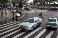 Two taxis in a rain day in Shanghai, China. Volkswagen Santana taxis manufactured in a Shanghai joint venture with the German car. Shanghai has approximately 45,000 taxis, operated by over 150 taxi companies. Several companies have taxis in their own colors. There are seven more popular companies - Dazhong Taxi Company with their cars in sky blue; Qiangsheng with their cars in orange; Jinjiang white; Bashi green; Haibo sapphire blue; Fanlanhong red; and Lanse Lianmeng in navy blue. Of all the companies, Dazhong and Qiangsheng are most strongly recommended. Taking taxis in Shanghai is more expensive than in other cities. In the daytime, the price is CNY13