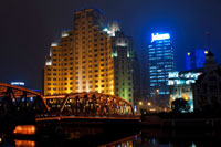 Shanghai puente Jardín. Suzhou Creek, Waibaidu (Jardín) Bridge, iluminado por la noche, Shanghai, China. El puente Waibaidu, Waibaidu Qiáo, llamado el puente del jardín en Inglés, es el primer puente completamente de acero, y el único ejemplo sobreviviente de un puente de braguero camello, en China. El cuarto puente exterior construido en su lugar desde 1856, en el de aguas abajo de la desembocadura del río Suzhou, cerca de su confluencia con el río Huangpu, al lado del Bund en el centro de Shanghai, que conecta los distritos de Huangpu y Hongkou, se abrió el puente actual el 20 de enero de 1908. Con su rica historia y un diseño único del puente Waibaidu es uno de los símbolos de Shanghai. Su imagen moderna e industrial puede considerarse como puente símbolo de la ciudad. El 15 de febrero de 1994, el Gobierno Municipal de Shanghai declaró el puente un ejemplo de la arquitectura del Patrimonio, y una de las estructuras más notables en Shanghai. En una metrópoli en constante cambio, el Puente Waibaidu