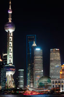 Pudong Skyline, by night, Shanghai, China. Skyline of Pudong as seen from the Bund, with landmark Oriental Pearl tower and Jin Mao tower, Shanghai, China. The word "bund" means an embankment or an embanked quay. The word comes from the Persian word band, through Hindustani, meaning an embankment, levee or dam (a cognate of English terms "bind", "bond" and "band", and the German word "Bund", etc.). It is thus named after the bunds/levees in Baghdad along the Tigris, when the Baghdadi Jews such as the prominent Sassoon family settled their business in Shanghai in the 19th century and built heavily on the bund on the Huangpo. In these Chinese port cities, the English term came to mean, especially, the embanked quay along the shore. In English, "Bund" is pronounced to rhyme with "fund".