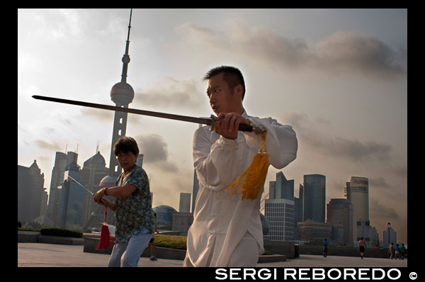 China, Shanghai, por la mañana el ejercicio de tai chi en el Bund. Shanghi Bund: Temprano tai chi ejercicios de la mañana con las espadas en el Bund en Shanghai China. Las mejores lecciones taichi que he tenido eran de un tipo viejo que practicaba fuera a las 7 am cada mañana. Aprendí 4 técnicas excelentes que todavía utilizo en mi entrenamiento MMA de modo regular un método de captura de una patada y tirar a tu oponente, la reorientación de un puñetazo recto y contrarrestar en el mismo movimiento, la lucha contra el doble underhooks con un lanzamiento, y escapar de un cerradura hombro mientras la configuración de su cuenta. Es un arte marcial realmente fascinante, porque cada uno de los movimientos de la danza como representa una técnica de lucha práctica sencilla o estrategia, pero es difícil ver cómo los movimientos se traducen en aplicaciones de combate sin un maestro en el arte demostrarlo. Pero de cualquier manera, incluso sin un maestro de kung-fu, las formas mismas son un gran ejercicio de bajo impacto que se puede encontrar en toda la ciudad de forma gratuita todas las mañanas. La mayoría de los ancianos en los parques no le importará si etiquetas a lo largo, acaba de aparecer temprano y asegúrese de preguntar primero si está bien para unirse a ellos. El Bund (que significa el "terraplén") se refiere al famoso paseo marítimo de Shanghai corriendo a lo largo de la orilla oeste del río Huangpu, que forma el límite oriental de la antigua ciudad de Shanghai. Una vez que un camino de sirga fangosa para barcos a lo largo del río, el Bund era donde las potencias extranjeras que entraron en Shanghai después de la Guerra del Opio de 1842 erigieron sus bancos de estilo occidental y distintas casas comerciales. Desde aquí, Shanghai se convirtió en líder de la ciudad de Asia en los años 1920 y 1930, un centro comercial y financiero cosmopolita y próspera. Muchas de las estructuras coloniales impresionantes que ver la fecha de hoy a partir de ese momento próspero y se han convertido en una parte indeleble de paisaje urbano de Shanghai. Después de 1949, la calle llegó a simbolizar el dominio occidental sobre China y fue clausurada.