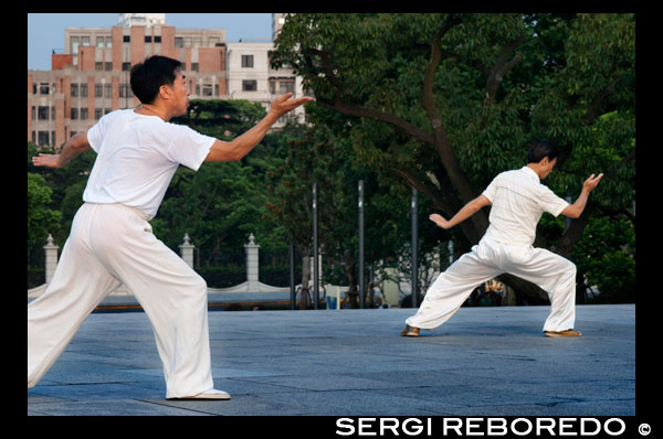 China, Shanghai, por la mañana el ejercicio de tai chi en el Bund. Shanghi Bund: Temprano tai chi ejercicios de la mañana con las espadas en el Bund en Shanghai China. Las mejores lecciones taichi que he tenido eran de un tipo viejo que practicaba fuera a las 7 am cada mañana. Aprendí 4 técnicas excelentes que todavía utilizo en mi entrenamiento MMA de modo regular un método de captura de una patada y tirar a tu oponente, la reorientación de un puñetazo recto y contrarrestar en el mismo movimiento, la lucha contra el doble underhooks con un lanzamiento, y escapar de un cerradura hombro mientras la configuración de su cuenta. Es un arte marcial realmente fascinante, porque cada uno de los movimientos de la danza como representa una técnica de lucha práctica sencilla o estrategia, pero es difícil ver cómo los movimientos se traducen en aplicaciones de combate sin un maestro en el arte demostrarlo. Pero de cualquier manera, incluso sin un maestro de kung-fu, las formas mismas son un gran ejercicio de bajo impacto que se puede encontrar en toda la ciudad de forma gratuita todas las mañanas. La mayoría de los ancianos en los parques no le importará si etiquetas a lo largo, acaba de aparecer temprano y asegúrese de preguntar primero si está bien para unirse a ellos. El Bund (que significa el "terraplén") se refiere al famoso paseo marítimo de Shanghai corriendo a lo largo de la orilla oeste del río Huangpu, que forma el límite oriental de la antigua ciudad de Shanghai. Una vez que un camino de sirga fangosa para barcos a lo largo del río, el Bund era donde las potencias extranjeras que entraron en Shanghai después de la Guerra del Opio de 1842 erigieron sus bancos de estilo occidental y distintas casas comerciales. Desde aquí, Shanghai se convirtió en líder de la ciudad de Asia en los años 1920 y 1930, un centro comercial y financiero cosmopolita y próspera. Muchas de las estructuras coloniales impresionantes que ver la fecha de hoy a partir de ese momento próspero y se han convertido en una parte indeleble de paisaje urbano de Shanghai. Después de 1949, la calle llegó a simbolizar el dominio occidental sobre China y fue clausurada.