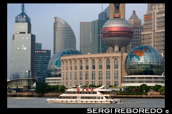 Pudong Skyline, Shanghai, Xina. Horitzó de Pudong, vist des del Bund, amb Torre de marca de la Perla Oriental i la torre Jin Mao, Xangai, Xina. La paraula "bund" significa un terraplè o una molla terraplenat. La paraula prové de la paraula persa banda, a través d'indostánica, el que significa un terraplè, dic o presa (un cognado de termes en anglès "lligar", "bons" i "banda", i la paraula alemanya "Bund", etc.). Per tant, es nomena després de les federacions / dics a Bagdad al llarg del Tigris, quan els jueus Baghdadi com la prominent família Sassoon establir els seus negocis a Xangai al segle 19 i construït en gran mesura en el Bund al Huangpo. En aquestes ciutats portuàries xineses, el terme anglès va arribar a significar, sobretot, el moll amb dic al llarg de la riba. En Anglès, "Bund" es pronuncia per rimar amb "fons". Hi ha nombrosos llocs a l'Índia, la Xina i el Japó, que són anomenats "bons" (per exemple, el Yokohama Bund). No obstant això, "El Bund", sense reserves pel que fa a la ubicació, en general es refereix a aquest tram de la riba del riu terraplenament a Xangai. El nom xinès per al Bund no està relacionada en significat: significa literalment el "banc d'exterior", en referència al riu Huangpu, perquè aquesta part de la vora del riu es troba riu avall de la zona de "banc d'interior" al costat de l'antiga ciutat emmurallada de Xangai. El Shanghai Bund té dotzenes d'edificis històrics, que voregen el riu Huangpu, que nombrosos bancs un cop allotjats i cases comercials del Regne Unit, França, Estats Units, Itàlia, Rússia, Alemanya, Japó, els Països Baixos i Bèlgica, així com el consolats de Rússia i Gran Bretanya, un diari, el Club de Xangai i el Club Maçònic. El Bund es troba al nord de l'antiga ciutat emmurallada de Xangai. Al principi va ser un assentament britànic; més tard, els assentaments britànics i nord-americans es van combinar en l'Acord internacional. Magnífics edificis comercials en l'estil Beaux Arts van sorgir en els anys al voltant de la volta del segle 20 com el Bund es va convertir en un important centre financer d'Àsia Oriental. Directament al sud, i al nord-est de l'antiga ciutat emmurallada, l'ex Bund francès (el quai de França, part de la Concessió Francesa de Xangai) era d'una mida comparable al Bund però va funcionar més com un treball al port.