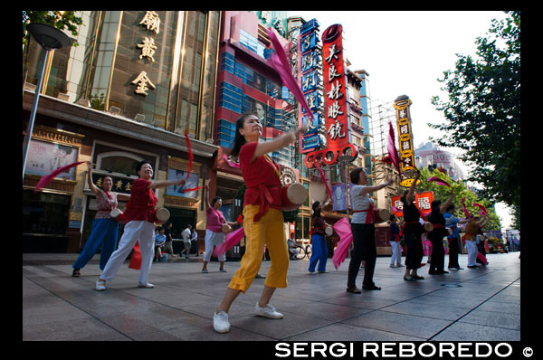 China, Shanghai, Nanjing Road, tai chi, exercises, people before opening the shops. Evening tai chi group exercising on Nanjing Dong Lu, Shanghai. Nanjing Road (Chinese: ???; pinyin: Nánj?ng Lù) is the main shopping street of Shanghai, China, and is one of the world's busiest shopping streets. It is named after the city of Nanjing, capital of Jiangsu province neighbouring Shanghai. Today's Nanjing Road comprises two sections, Nanjing Road East and Nanjing Road West. In some contexts, "Nanjing Road" refers only to what was pre-1945 Nanjing Road, today's Nanjing Road East, which is largely pedestrianised. Before the adoption of the pinyin romanisation in the 1950s, its name was rendered as Nanking Road in English. The history of Nanjing Road can be traced back to the year 1845. At that time it was called “Park Lane”, which stretched from the Bund to He’nan Road. In 1854, it was extended to Zhejiang Road, and eight years later, once more extended to Xizang Road. In 1862, it was named formally “Nanking Road” by the Municipal Council, which administered the International Settlement. In Chinese it was usually referred to as the Main Road (???). Around 1930 it was a bustling street with at least one reported casino (probably at nr. 181).[citation needed] In 1943 the International Settlement was annulled, and after World War Two the government changed its name from Nanking Road to "East Nanjing Road", meanwhile they also renamed the former Bubbling Well Road "West Nanjing Road", and the general name of the two roads became "Nanjing Road", comprising five kilometres total length.