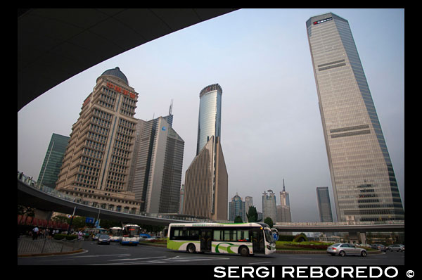 Skyscrapers in Lujiazui financial district, in Pudong, in Shanghai, China. Shanghai International Finance Centre, usually abbreviated as Shanghai IFC, is a commercial building complex and a shopping centre (branded Shanghai IFC mall) in Shanghai. It incorporates two tower blocks at 249.9 metres (south tower) and 259.9 metres (north tower) housing offices and a hotel, and an 85-metre tall multi-storey building behind and between the two towers.  Shanghai IFC is located in Lujiazui, in Pudong, Shanghai. It occupies a prominent position southeast of the Lujiazui roundabout, diagonally across from the Oriental Pearl Tower and across the road from Super Brand Mall. It is adjacent to Lujiazui Station on Metro Line 2, and can be accessed directly from the underground station via a tunnel.  The south tower of Shanghai IFC and part of the multistorey building was completed in 2009, while the north tower and the rest of the complex was completed in 2010. Work continued for several years afterwards on peripheral aspects of the development, including landscaping and footbridge connections to nearby buildings and Lujiazui Central Park.  The Ritz-Carlton Hotel occupies the south tower, while the north tower houses the current Shanghai headquarters of HSBC in China. Other prominent tenants of the complex include an Apple Store under the sunken forecourt of the building (topped by a cylindrical glass skylight rising from the forecourt), a multi-screen cinema, and a Citysuper supermarket. The remainder of the retail area is largely taken up by upscale chain restaurants and international luxury fashion brands.