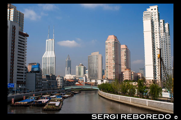 Horizonte de Pudong distrito financiero, y el puente sobre el río Wusong (Suzhou Creek), Shanghai, China. Suzhou Creek, también llamado río Wusong, es un río que pasa por el centro de la ciudad de Shanghai. Lleva el nombre de la vecina ciudad de Suzhou, Jiangsu, la solución predominante en esta área antes de la subida de Shanghai como una metrópoli. Uno de los principales puntos de venta del lago Tai en Wujiang Distrito de Suzhou, Suzhou Creek es de 125 kilómetros (78 millas) de largo, de los cuales 54 kilometros se encuentran dentro de la región administrativa de Shanghai y 24 kilometros en partes muy urbanizadas de la ciudad. Desemboca en el río Huangpu en el extremo norte del Bund en el distrito de Huangpu. Suzhou Creek ha desempeñado un papel importante por ser la línea de demarcación entre las esferas políticas de influencias a lo largo de la historia de Shanghai. Después del Tratado de Nanjing obligó a China a abrir en 1842 y Shanghai se convirtió en un puerto de comercio internacional, el río forma el límite entre la concesión británica (Banco del Sur) y el establecimiento americano (banco norte) hasta que ambas concesiones se fusionaron en el Acuerdo Internacional en 1863. Cuando los japoneses invadieron Shanghai en 1937, el río forma el límite entre el Acuerdo Internacional (Sur) y la concesión japonesa (Norte).