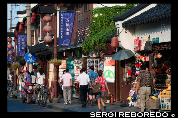 Compres botigues al voltant de petits a la Ciutat Vella, Shanghai, Xina. La ciutat vella de Xangai, Shangh? I L? O Chengxi? Ng, també conegut anteriorment com la ciutat xinesa, és el nucli urbà tradicional de Xangai, Xina. El seu límit es definia per una muralla defensiva. La Ciutat Vella va ser el seient de comtat per l'antic comtat de Xangai. Amb l'adveniment de les concessions estrangeres a Xangai, la ciutat vella es va convertir en només una part del nucli urbà de Xangai, però va continuar en les dècades per ser la seu de l'autoritat de la Xina a Xangai. Les característiques notables inclouen el Temple del Déu de la Ciutat, situat al centre del nucli antic i està connectat amb el Jardí Yuyuan. Amb l'excepció de dues seccions curtes, les parets van ser demolides el 1912, i una àmplia avinguda circular construïda sobre l'antiga muralla i el fossat: la meitat sud es va anomenar el "Zhonghua Road" i la meitat nord de la "Minguo Road" (junts fent dalt "Zhonghua Minguo", o "República de la Xina" en xinès). (La meitat nord va passar a cridar-se "Renmin Road" ("Camí del Poble") en 1950 pel nou govern comunista de Xangai). La Ciutat Vella va ser durant dècades en gran part confrontant amb l'antic Districte Nanshi, que ara és part de districte de Huangpu.