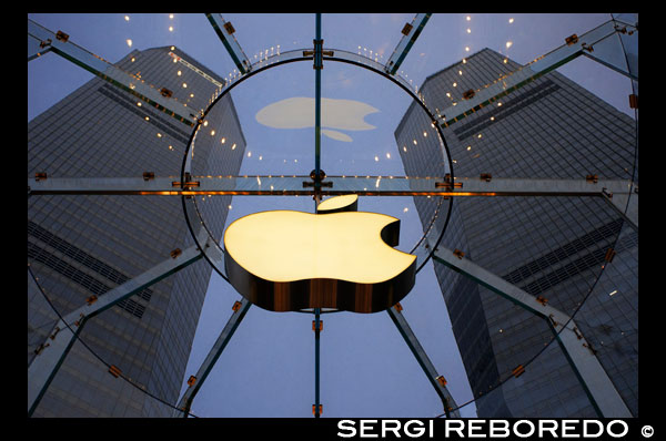 Tienda de Apple ordenador en el distrito financiero de Lujiazui, en Pudong, en Shanghai, China. Vista del gran almacén moderno Apple en Shanghai China. Apple Store Pudong delante de Shanghai IFC Sur y Torre Norte (edificio HSBC) en el distrito de Pudong, Shanghai, China. Shanghai International Finance Centre, generalmente abreviado como Shanghai IFC, es un complejo de edificios comerciales y un centro comercial (marca comercial de Shanghai IFC) en Shanghai. Incorpora dos bloques de pisos en 249,9 metros (torre sur) y 259,9 metros (torre norte) oficinas de vivienda y un hotel y un edificio alto de 85 metros de varios pisos detrás y entre las dos torres. Shanghai IFC se encuentra en Lujiazui, en Pudong, Shanghai. Ocupa un lugar destacado al sureste de la rotonda de Lujiazui, en diagonal a través de la Torre de la Perla Oriental y al otro lado de la carretera de Super Brand Mall. Se encuentra junto a la estación de Lujiazui en Línea 2 del Metro, y se puede acceder directamente desde la estación de metro a través de un túnel. La torre sur de Shanghai IFC y parte del edificio de varios pisos se completó en 2009, mientras que se completó la torre norte y el resto del complejo en 2010. El trabajo continuó durante varios años después en aspectos periféricos del desarrollo, incluidas las conexiones de jardinería y pasarela a los edificios cercanos y Lujiazui central Park. The Ritz-Carlton Hotel ocupa la torre sur, mientras que la torre norte se encuentra la actual sede de Shanghai de HSBC en China. Otros inquilinos prominentes del complejo incluyen una tienda de Apple bajo el patio hundido del edificio (coronado por una claraboya de cristal cilíndrico que se eleva desde la estación de servicio), un multicine y un supermercado Citysuper. El resto de la superficie comercial está en gran parte ocupada por las cadenas de restaurantes de lujo y de marcas internacionales de moda de lujo.