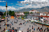 Vistes des del temple de Jokhang de la plaça Barkhor i el Palau del Potala al fons. Propera al santuari de Jokhang, l'animada plaça Barkhor i els carrers adjacents s'impregnen de l'ambient de l'antiga ciutat tibetana de Lhasa. És una zona plena de contrastos: d'una banda, és una de les àrees més sagrades del Tibet i està inundada de pelegrins, monjos, monges i temples. De l'altra, és l'eix del comerç de Lhasa. Els comerciants del carrer, els venedors ambulants i els homes de negocis es mouen al voltant de l'àrea de Barkhor. En l'actualitat, aquesta zona no és simplement part d'un circuit de pelegrinatge, sinó també la part més important de la població. Aquí es poden comprar les coses més curioses: ganivets tibetans, vestits i barrets tibetans, tapisseries, instruments musicals religiosos, objectes d'or i plata ... L'oferta de records màgics és il · limitada.
