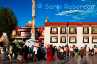 Pelegrins costat del temple Jokhang. Lhasa. Només es pot viure l'autèntic i fantàstic clima Tibetà al barri Barkhor, allà al temple Jokhang és fantàstic seguir el circuit de peregrinació més sagrat del Tibet des del segle VII, on llocs amb vendes de fruites, verdures, tèxtil souvenirs etc. proveeixen als pelegrins que donen voltes al temple en direcció a les agulles del rellotge.