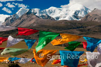 Banderes d'oració a la base de la Muntanya Nyenchen Tanglha de 7111 metres d'alçada. Les banderes tibetanes d'oració flamegen sobre tot el món de la cultura tibetana. Una típica bandera d'oració té en la seva imatge central un cavall que porta a l'esquena les Tres Joies en flames. Aquest cavall és conegut com el Cavall de Vent i li atorga a les banderes seu nom en tibetà "Lung-Ta". Les tres joies simbolitzen a Budha (l'estat d'Il · luminació), el Dharma (els ensenyaments budistes) i la Sangha (la Comunitat budista).