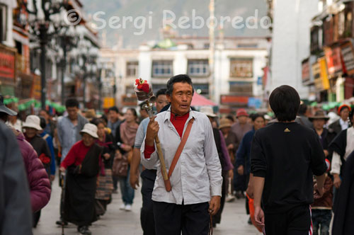 Un pelegrí fent girar el seu molí d'oració mentre fa el Kora al voltant del temple Jokhang. "Om mani padme hum" repeteixen fins la sacietat milers de tibetans en les seves incansables voltes al Temple de Jokhang, el més famós dels temples budistes de Lhasa al Tibet, el centre espiritual de la ciutat. És la zona coneguda com Barkor, el veritable cor de la ciutat. Mentre resen els seus mantres no deixen de donar voltes als seus molins d'oració, sempre en el sentit de les agulles del rellotge.