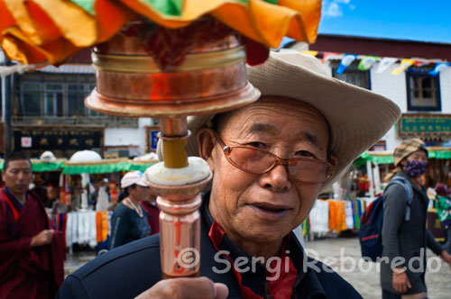 Pilgrims around the Jokhang Temple. Lhasa. Every day thousands of Tibetans pray and sing prayers doing what they call the kora around the temple Jokhabg. Jokhang Temple is the largest temple of Tibetan Buddhism in Lhasa. It is located about a mile of the Potala Palace immersed in the busiest district of the city. No doubt impressed by the path leading to the Temple. In the main entrance there is a place where you usually set a market where you can buy all kinds of souvenirs, clothing and art from the region, in fact is full of shops that refer to Tibetan art.