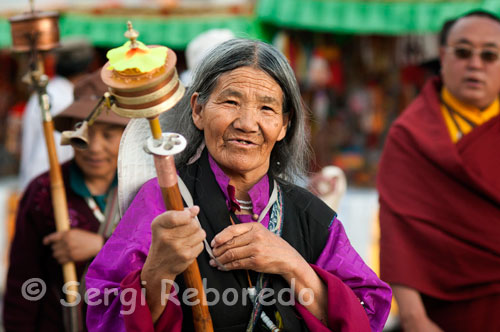 Lo peregrinos hacen girar su molino de oración mientras hacen el Kora alrededor del templo Jokhang. Lhasa.  Los hay de todos tipos y tamaños, desde algunos que caben en la palma de la mano hasta algunos enormes que se encuentran en monasterios y hasta los hay movidos por sistema eléctrico o por la  agua de lo ríos. Lleva en su interior llevan unos pergaminos con mantras escritos a mano, normalmente en su antiguo lengua, el sánscrito, pergaminos que pueden llegar tener de diez a doce metros de longitud perfectamente enrollados en su interior y que con el movimiento elevan al cielo sus oraciones y plegarias.