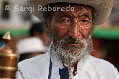 Un peregrino hace girar su molino de oración mientras hace el Kora alrededor del templo Jokhang. Lhasa. En todos los templos budistas hay infinidad de estos molinos y los peregrinos pasan por ellos haciéndolos girar en sentido contrario a las manecillas de reloj. Así, sus plegarias son atentidas por las deidades a las que se les reza. Fundado en la India del norte en el siglo XV antes de Cristo, el budismo es una de las grandes religiones del mundo. La doctrina de Buda se articula alrededor del tema del sufrimiento y de los medios de franquearlos. Después de haber sido difundido en la India durante varios siglos, esta religión despertó en el Extremo Oriente a una filosofía religiosa y a una ética original. Buda no dejo ningún escrito. Sus palabras fueron transmitidas oralmente por sus fieles y fueron reunidas en los textos sagrados.