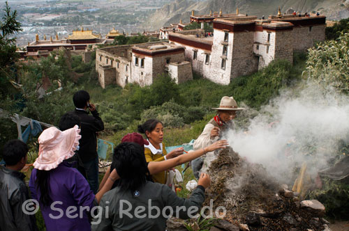 Drepung Monastery during the Yogurt Festival, also known as Shoton Festival. Pilgrims burning incense around Drepung. Generally, the festival takes place Shoton the last two weeks of August, the exact dates change from year to year depending on the lunar calendar. This event is also known as the festival of opera, and you will see performances by singers and acrobats throughout the city and especially in the summer palace of the Dalai Lama, known as Norbalinka.