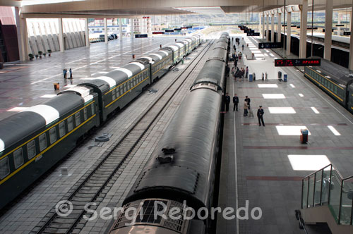 Estació de tren de Lhasa. Des que s'obrís la ruta ferroviària entre Beijing i Lhasa, l'any 2006, molts turistes trien aquesta via per arribar al Tibet. Aquest és un recorregut de 4.062 quilòmetres entre Pequín i Lhasa, gairebé 48 hores travessant algunes de les zones més profundes de la Xina. Tot i que el projecte va ser ideat el 1956, fins a 2006 la línia no ha quedat oberta al trànsit. Més de 3.300 milions d'euros i 30.000 treballadors han ajudat a construir la línia ferroviària més alta i una de les més complexes també, doncs 960 quilòmetres es realitzen a més de 4.000 metres d'altura i 550 quilòmetres transcorren sobre espesses capes de gel, per la qual que va ser necessari construir pilars elevats per sobre del terreny i dotar la via amb un sistema tèrmic contra gelades. A les muntanyes Kunlun travessarem el túnel més llarg del món construït sobre sòl gelat i arribarem al punt ferroviari més alt del planeta a l'estació de Tanggula. No obstant això, el tren és objecte de disputes entre el règim xinès i els tibetans partidaris de Dalai Lama, ja que mentre els primers ho defensen com un símbol de desenvolupament per a l'economia local, els segons argumenten que la línia de ferrocarril fomentarà l'arribada massiva de l'ètnia Han, el que podria ocasionar l'extinció de la cultura tibetana.