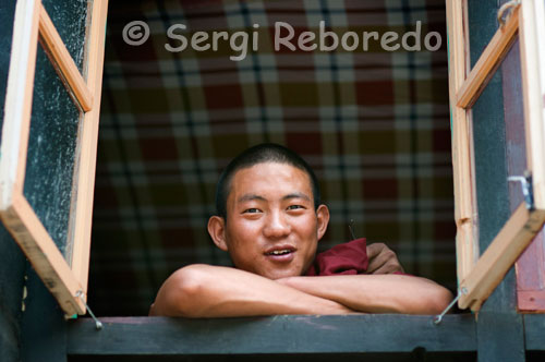 Un monje detrás de una ventana en el interior del Monasterio Tashilumpo, ubicado en Shigatse, Tibet.  El Monasterio de Tashilumpo: Con el pico de Drolmari (Montañas de Tara) en el fondo, el monasterio de Tashilunpo brilla cada día al amanecer. Esta situado al oeste de Shigatse. El Monasterio, También conocido como 'Mente de Gloria', fue fundado en 1447 por el soberano y discípulo de Tsongkhapa (fundador de la secta Gelukpa), Gendun Drup. Gendun Drup fue nombrado el primer Dalai Lama Después de su muerte. Debido a su asociación con el fundador de Geluk, el monasterio es considerado como uno de los más importantes monasterio del orden Geluk.