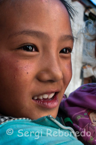 Primer plano de una niña en las calles del casco antiguo de Gyantse. Cuando uno recorre las calles del viejo Gyantse percibe, si lo comparamos con otras poblaciones principales como Lhasa o Shigatse, que su trazado no ha cambiado en demasía a causa de la modernización desenfrenada emprendida por el gobierno de Pekín, y por suerte, aunque cada vez más aislados por la presión de un progreso que estigmatiza y demonifica cualquier atisbo de la cultura autóctona, todavía podemos contemplar coletazos de sus encantos tradicionales en los barrios marginales de la ciudad. 