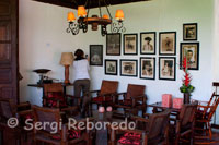 Mobiliario de época en el Hotel Casa de campo El Delirio. Quindío. Esta rodeada de amplias zonas verdes y desde ella se observan el espectacular paisaje de la cordillera central, la hoya del Quindío con varios de sus municipios y en días despejados, la magnificencia de las cumbres nevadas del Tolima, el Ruíz y el Quindío.La finca conserva sus cultivos tradicionales de café, a los que se puede acceder a través de un sendero ecológico que desciende por un guadual hasta el fondo de una quebrada, en medio de cultivos de heliconias, y ascienda bordeando los cafetos sombreados por mas de trescientos nogales cafeteros.