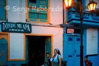 Donde mi apa. Fonda. Algunos bares y alojamientos de Salento. Quindío. Salento es un municipio colombiano en el departamento del Quindío. Llamado el padre del Quindío por ser el municipio más antiguo de este departamento, es conocido como el municipio Cuna del árbol Nacional "La Palma de Cera", posee una gran variedad de atractivos turísticos entre ellos El Valle de Cocora en donde se puede encontrar un paisaje lleno de naturaleza y hacer caminatas ecológicas y disfrutar de los hermosos paisajes de esta localidad. Según un acuerdo del Honorable Concejo Municipal, se tomó como fecha de fundación el cinco de enero de 1851 Cada año se celebran las tradicionales fiestas aniversarias de su fundación entre el dos y el doce de Enero. La temperatura promedio es de 15 grados centígrados y tiene una población aproximada en el caso urbano de 3000 habitantes y en la zona rural de 5500 habitantes. Salento está situado al norte de la ciudad de Armenia a nueve kilómetros por la margen derecha ( Posada Alemana) de la carretera que de Armenia conduce a Pereira, luego de abandonar la autopista por un tramo de carretera en muy buen estado en un trayecto de otros nueve kilómetros. Se distingue por la arquitectura de su plaza, y de sus casas antiguas en bahareque y en tapias de barro, por la amabilidad y gentileza de sus pobladores, por sus hermosos paisajes y por su excelente clima. Veredas Navarco: Es una vereda que posee 23 afluentes de Agua, 2 ríos llamados Navarco del cuál deriva la vereda su Nombre y Boquerón que delimita la vereda en su parte Norte. Posee una reserva natural muy extensa en fauna y flora en ella se construira proximamente la reserva hídrica del Quindío. Tiene una escuela llamada Niños de la esperanza construida sobre un cementerio indigena. La temperatura promedio es de 6 a 18 grados centigrados. 