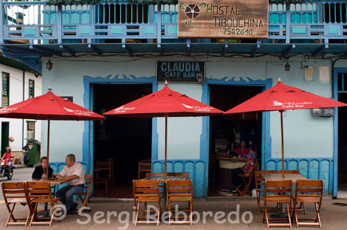 Claudia Café Bar. Uno de los cafes restaurante ubicados en la plaza central de Filandia. GASTRONOMÍA: Los frijoles con garra, servidos con carne, arroz, patacones, aguacate, huevo, chorizo, chicharrón y plátano madurito crean esta maravilla de la cocina llamada bandeja paisa. Las truchas con patacón en Salento es uno de los platos mas apetecidos por turistas.  La mazamorra de maíz endulzada con panela o la aguapanelita con queso son bebidas típicas,  los buñuelos con natilla, las solteritas, las obleas con crema de leche y las brevas con queso. El licor tradicional de la región es el aguardiente. HOTELERÍA TRADICIONAL: De manera simultánea el crecimiento cuantitativo y cualitativo del servicio de los alojamientos rurales, la hotelería tradicional del Quindío, en los últimos años, ha crecido notablemente. Su capacidad, estimada en 3.148 camas, es un potencial que permite, aparte de atender un flujo alto de turistas en todas las épocas, celebrar en el departamento grandes eventos de carácter económico, cultural y deportivo, ya sean de orden nacional e internacional. De igual forma su calidad en la atención al cliente se ha convertido, por su eficiencia y amabilidad, en un factor que consolida el desarrollo turístico de la región. En el Quindío hay hoteles para todos los gustos y todas las posibilidades económicas; desde sencillos y austeros hasta aquellos que ofrecen grandes y bellas edificaciones, las cuales sustentan, en su diseño y en sus comodidades – y en las estrellas que califican su desempeño – la excelencia de su servicio y de su hospitalidad. 