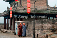 Monjos caminant per la part superior de la muralla de Xi'an. Tot i no ser tan famosa com altres, és la muralla millor conservada de totes les que defensaven les ciutats xineses. Va ser construïda entre 1374 i 1378 sobre la ciutat prohibida de la dinastia Ming i avui en dia encara segueix íntegrament en peu.