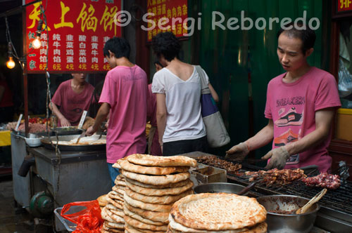 Puesto de comida callejera en el barrio musulman de Xi´an. Además de las compras; si algo que a primera vista llama la atención es la gran cantidad de puestos de comida; en los cuales es posible comer a cualquier hora del día. Es un lugar que siempre se encuentra animado. En los hornos a pie de calle se elaboran unas deliciosas tortas de pan a las que luego se le pueden añadir infinidad de ingredientes; los sabrosísimos dulces fritos con aceite de sésamo también juegan un papel importantísimo; al igual que los frutos secos que se encuentran a cada cinco pasos.