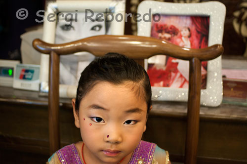 Una niña maquillada en el interior de un estudio fotográfico especializado en bodas en el barrio musulman de Xi´an. Xian tiene mucho que ofrecer además de los Guerreros; especialmente si viajas con niños; las fortificaciones de la ciudad se prestan para un corto paseo en bicicleta y dentro de la ciudad; en los mercados; bazares y callejones pasaran muy entretenidos!