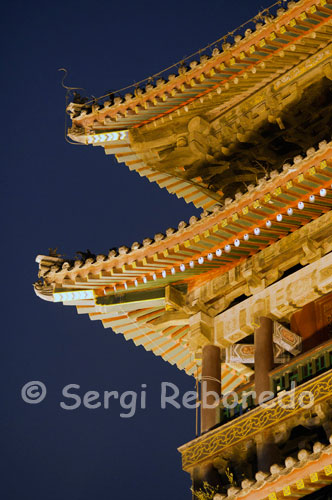 Side of the Drum Tower in Xi'an. In traditional Chinese style, and built in 1380 during the Ming Dynasty, the Drum Tower had the same function as that of the Bell. It is located on a stone platform, on which stands a wooden building of two floors with a total height of 34 meters from where you have good views of the city when the sky allows. Inside a giant drum is shown that in antiquity resounded for miles every evening, announcing the closing of the gates in the wall. Currently, in an adjacent room musical performances are held daily and are on display outside a dozen large drums.