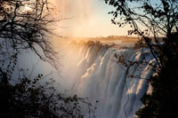 Views of the Victoria Falls.  The Victoria Falls are one of the world's most spectacular plunges. The 2km(1.2mi)-wide Zambezi River drops more than 100m (328ft) into a steeply-walled gorge. The Zambian side of Victoria Falls has long played second fiddle to its better-known Zimbabwean counterpart, but trouble next door means Livingstone is positively booming. For close-up views of the Eastern Cataract, nothing beats the hair-raising (and hair-wetting) walk across the footbridge, through swirling clouds of mist, to a sheer buttress called the Knife Edge. If the water is low and the wind favourable, you'll be treated to a magnificent view of the falls and the yawning abyss below the Zambezi Bridge. Adrenaline junkies can indulge in white-water rafting, abseiling, river-boating, jet-boating, bungee jumping and a host of airborne activities. At certain times of year it is even possible to visit Livingstone Island and swim at the very edge of the Falls, though sadly it's no longer free. Don't get so caught up with activities that you miss one of the most spectacular waterfalls in the world. 