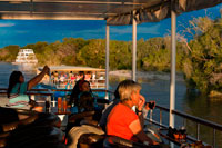Crucero a lo largo de las Cataratas Victoria a bordo del "African Queen". Cruceros al atardecer en el río Zambezi en las Cataratas Victoria ver las vainas y los elefantes a veces cruzan el río Zambeze hipopótamo. Los clientes son recogidos de su hotel o albergue a las 15:30 en invierno y de 16:00 horas en los meses de verano y se transfieren al sitio embarcadero. Salidas de Cruceros a las 16:00 horas en invierno y 16:30 en verano. Siguiendo este crucero al atardecer, será trasladado de regreso a su hotel entre las 18:30 hrs y las 19:00 hrs (invierno y verano respectivamente). En el embarcadero de huéspedes secundarios son recibidos por una banda tradicional africana antes de firmar el formulario de indemnización estándar. Después de una charla de seguridad y hablar los visitantes abordan el barco safari. Con salida de aguas abajo, serpenteando a través de las islas, los guías le hablarán y describir la flora y la fauna, así como la prolífica vida de aves y vida silvestre.