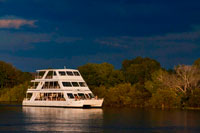 Crucero a lo largo de las Cataratas Victoria a bordo del "African Queen" . Otros barcos que navegan en el río Zambezi . Este es el barco "Lady Livingstone " . El recientemente construido señora Livingstone famoso conocido como " La joya del Zambezi " tiene una capacidad de 144 pax . Los huéspedes son recibidos en sus respectivos hoteles / Lodges y transferidos al David Livingstone Safari Lodge & Spa . El crucero tiene lugar a lo largo de la frontera del río del Parque Nacional de Mosi -Oa- Tunya , el tiempo total de crucero es de aproximadamente 2 horas. Durante el crucero , los clientes tienden a ver hipopótamos , cocodrilos y algunos buenos pájaros . Otros posibles avistamientos de juego son elefantes, jirafas , búfalos y dinero. Un experimentado guía acompaña a cada crucero y tiene buen conocimiento sobre la fauna y la historia local de la zona . Excelentes aperitivos fríos y calientes se sirven a bordo y el bar está bien surtido con los espíritus , buenos vinos , cervezas y refrescos. Bocadillos y bebidas están incluidas en el precio y se sirve durante todo el crucero . Pick up horarios son 16h00 en verano (agosto a abril) y 15h30 en invierno (mayo a julio).