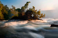 Sunset in the Victoria Falls. Victoria Falls on the border between Zimbabwe and Zambia has some of the most breath taking views you'll ever encounter on the African continent, if not the world. The massive sheet of falling water and the spray it produces is mesmerizing to say the least. The nearby Victoria Falls National Park and the towns of Victoria Falls and Livingstone offer additional pleasures to the discerning visitor. The Victoria Falls is one of the most popular attractions in Southern Africa, where you can explore the African wilderness as Dr. Livingstone did so many years ago. Getting to and from Victoria Falls is a breeze as the Victoria Falls Airport accommodates flights from Johannesburg, Windhoek, Harare and Bulawayo. There are plans to expand the runway to accommodate bigger planes, which in turn could mean direct flights from overseas destinations such as Europe and the Americas. There is decent transfer services usually arranged by the lodges and your journey should be safe and sound. 