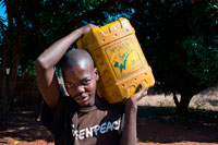 Uno de los habitantes de Mukuni pueblo trayendo un jerican agua. Lleva una camiseta de Greenpeace. Mukuni Village - una experiencia cultural única que le da al visitante una idea de manera moderna , pero claramente sin tiempo, de la vida de las personas Toka Leya que viven allí. Este pueblo está formado por las granjas de más de 1.000 familias y tiene una población total de cerca de 6 000 personas de Zambia. Las Casas se colocan en la cima de una de las antiguas dunas de arena que se encuentran en la región. Con el aumento de las precipitaciones en los últimos 100 000 años estas dunas están bien cubiertos de vegetación y bosques. Los habitantes de Mukuni son claramente respetuosos con el medio ambiente y , como tal, el pueblo, que cubre unas 20 hectáreas , tiene muchos árboles preciosos y una gran cantidad de éstos se ha animado y probablemente plantados por los vecinos , ya que proporcionan la fruta y sombra, así como garantizar la estabilidad de los suelos arenosos. Situado en la parte sur-oriental de la aldea , son las Casas de los líderes de la comunidad.