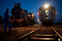 Livingstone Express luxury train at night. Collected from the Royal Livingstone Hotel, guests board the immaculate vintage first class Lounge carriage. Being either a 10th class No. 156 or a 12th class No. 204 locomotive, coal is shovelled and steam erupts, sending  you merrily pottering down the tracks. Departing three times a week, this luxury train leaves the station at 17h45. Once aboard, the trip will take you past Mosi-oa-Tunya Game Park's doorstep: a great opportunity to spot elephant, white rhino, buffalo as well as giraffe, zebra, hartebeest, bushbuck, impala, warthogs, baboons and monkeys. 19:00 sees you spoiled with a 6-course dinner, accompanied by your choice of fine wine, beer or soft drinks.  