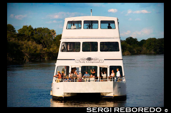 Cruise along the Victoria Falls aboard the " African Queen".  Other boats sailing in the Zambezi River. This is the “Lady Livingstone” boat.  River Cruises. Few places offer the dramatic sunsets that you'll find on the Zambezi River with plumes of spray and wildlife completing the scene. The sunset cruise on the Zambezi River is a definite must on any trip to Victoria Falls. Relax with a sundowner and snacks as you gaze out onto the banks of the river. Have your camera ready to capture one of the most amazing sunsets in Africa. You'll be sure to spot wildlife animals as they come down to the river for a drink after a hot day in the Zambezi National Park (Zimbabwe) and the Mosi-oa-Tunya National Park (Zambia). Sightings of elephant, giraffe and other resident game are common. There's always an abundance of hippos and crocodiles. Birdlife is superb and the Fisheagles will usually fill the scene with their calls. Cruises are available daily on request for breakfast, lunch, sunset and dinner and last for approximately 2 to 3 hours.  Transfers from hotels in both Livingstone and Vic Falls town are included. (*Park Fees excluded - applicable in Zimbabwe)  Sunset cruises - US$50 per person (Claim it for free!) Breakfast and lunch cruises - US$70 per person Dinner cruises - US$75 per person (advance bookings essential) Lodges further upstream the Zambezi in both Zimbabwe and Zambia offer sundowner cruises as part of the deal. These upper cruises tend to be quieter affairs than the revelling crowds on a few of the big party boats downstream. Whatever sparks your interest...they're all great fun! 