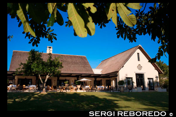 Garden and main entrance of the Royal Livingstone Hotel.  Stretching along the banks of the Zambezi River, consists of a series of 17 colonial-style buildings with deep verandas, set amidst indigenous trees and plants. The main hotel is a sequence of thatch-roofed buildings and incorporates the lounge, restaurant and bar. A stone’s throw away from the mighty Victoria Falls, the Royal Livingstone overlooks the smooth waters just before it plunges over the legendary waterfall creating a permanent water spray. The hotel has already been named as one of the 'Leading Hotels in the World' for its exceptional levels of service, fine dining, comfort and hospitality. It is a five-star colonial style, luxury hotel which has been designed to capture the opulence and elegance of times gone by.  173 spacious guest rooms are located in two-story clusters and are elegantly furnished with en-suite bathrooms which have a roomy shower and a Victorian bath. Each room also has a private verandah, overlooking the Zambezi River or the hotel's rolling lawns. There is a sophisticated dining room, or alternatively guests can enjoy meals al-fresco, by the pool or under the acacia trees. The Royal Livingstone is excellently situated for guests to take advantage of the many activities available on the Zambezi River, and around the Falls. Helicopter flights, bungee jumps and white water rafting are just a few examples. Alternatively guests can take their time to sit back and relax by the pool. The swimming pool visually links the river with the terraces of the hotel, with a sweeping timber deck in the swirling waters of the Zambezi. The resort's deep, shaded verandah, offers an uninterrupted view of the Zambezi and is the ideal place to curl up with a book from the well-stocked library. 