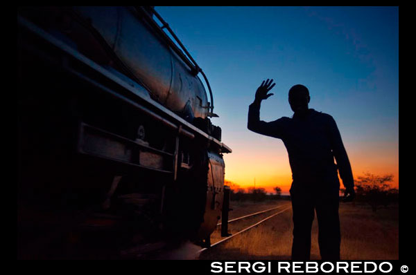 Los hombres negros dicen adiós a Livingstone expreso tren de lujo. El Royal Livingstone Express es un tren de vapor construido en la década de 1920 con los carros de estilo Pullman. Debido a la popularidad de esta experiencia de primera clase, el horario de los trenes ha, para los próximos tres meses, ha ampliado para incluir los miércoles, que le da la oportunidad de abordar el tren dos días a la semana. El viaje comenzará a las 17.00 horas los miércoles y sábados, independientemente de cuántas personas están a bordo. Si usted está en un grupo de 12 o más se puede subir al tren, los jueves y viernes también. Este tren restaurada, una empresa conjunta entre Sun International y BUSHTRACKS ÁFRICA, serpentea a través del suburbio Dambwa de Livingstone hacia el Parque Nacional Mosi-oa-Tunya, que corre paralela al río Zambezi. Usted tendrá la oportunidad de ver rinocerontes blancos, búfalos, elefantes y otros animales salvajes desde el tren. El tren cruza fuera del Parque Nacional de Mosi-Oa-Tunya sobre el río Sinde y se detiene a unos 17 kilómetros de Livingstone. Por este tiempo la oscuridad ha descendido sobre el valle de Zambezi y es hora para la cena. La experiencia gastronómica de seis platos que se sirve en los dos coches comedor, que forman parte de cinco vagones del tren con aire acondicionado - un coche del club / cocina, alquiler de salón y alquiler de observación. Después de la comida el tren bordes lentamente de nuevo a 'correr en torno a "la Sinde, proporcionando el maquinista una buena vista de los obstáculos en su camino para el viaje de regreso en la oscuridad, incluyendo los cursos de los elefantes! El viaje termina de vuelta en el viejo revestimiento Mulobezi aproximadamente a las 21h30.