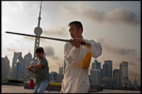XINA: Xangai, al matí l'exercici de tai-txi al Bund. Shanghi Bund: D'hora tai txi exercicis del matí amb les espases en el Bund a Xangai Xina. Les millors lliçons tai-txi que he tingut eren d'un tipus vell que practicava fora a les 7 am cada matí. Vaig aprendre abril tècniques excel·lents que encara utilitzo en el meu entrenament MMA de manera regular un mètode de captura d'un cop de peu i llençar al teu oponent, la reorientació d'un cop de puny recte i contrarestar en el mateix moviment, la lluita contra el doble underhooks amb un llançament, i escapar d'un pany espatlla mentre la configuració del seu compte. És un art marcial realment fascinant, perquè cada un dels moviments de la dansa com representa una tècnica de lluita pràctica senzilla o estratègia, però és difícil veure com els moviments es tradueixen en aplicacions de combat sense un mestre en l'art demostrar-ho. Però de qualsevol manera, fins i tot sense un mestre de kung-fu, les formes mateixes són un gran exercici de baix impacte que es pot trobar a tota la ciutat de forma gratuïta cada matí. La majoria dels ancians en els parcs no li importarà si etiquetes al llarg, acaba d'aparèixer d'hora i assegureu-vos de preguntar primer si està bé per unir-se a ells. El Bund (que significa el "terraplè") es refereix al famós passeig marítim de Xangai corrent al llarg de la riba oest del riu Huangpu, que forma el límit oriental de l'antiga ciutat de Xangai. Una vegada que un camí de sirga fangosa per vaixells al llarg del riu, el Bund era on les potències estrangeres que van entrar a Xangai després de la Guerra de l'Opi de 1842 van erigir els seus bancs d'estil occidental i diferents cases comercials. Des d'aquí, Xangai es va convertir en líder de la ciutat d'Àsia en els anys 1920 i 1930, un centre comercial i financer cosmopolita i pròspera. Moltes de les estructures colonials impressionants a veure la data d'avui a partir d'aquest moment pròsper i s'han convertit en una part indeleble de paisatge urbà de Xangai. Després de 1949, el carrer va arribar a simbolitzar el domini occidental sobre la Xina i va ser clausurada.