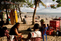 At dusk everyone gathers to watch the sunset, taking a beer on the beach of Kuta. Bali.