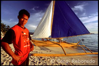 Sunset on the beach with crystalline waters. Sailing boat for practice. White beach. Boracay. 